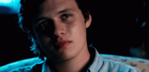 A Young Man Is Sitting In A Chair With His Eyes Closed And His Mouth Open . GIF
