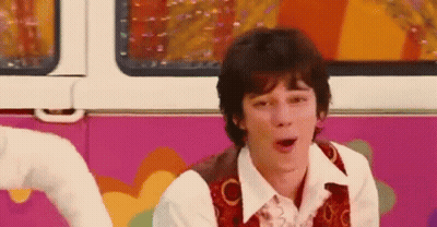 A Young Man Is Sitting In Front Of A Pink And White Van . GIF