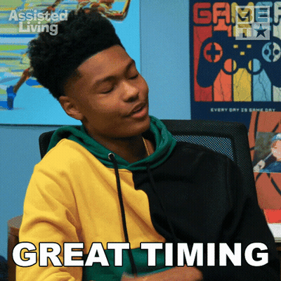 A Young Man Is Sitting In Front Of A Poster That Says Great Timing GIF
