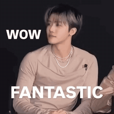 A Young Man Is Sitting In Front Of A Sign That Says Wow Fantastic . GIF