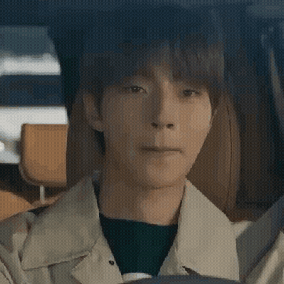 A Young Man Is Sitting In The Driver 'S Seat Of A Car And Making A Face . GIF