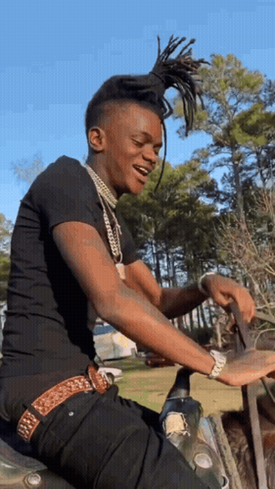 A Young Man Is Sitting On A Motorcycle In The Woods . GIF