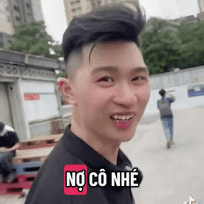 A Young Man Is Smiling And Making A Funny Face While Wearing A Black Shirt And A Backpack . GIF