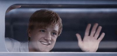 A Young Man Is Smiling And Waving His Hand GIF