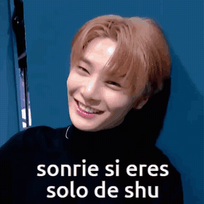 A Young Man Is Smiling And Wearing A Black Turtleneck . GIF