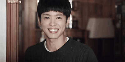 A Young Man Is Smiling For The Camera In A Room . GIF