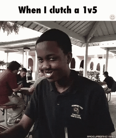 A Young Man Is Smiling While Sitting At A Picnic Table In Front Of A Group Of People . GIF