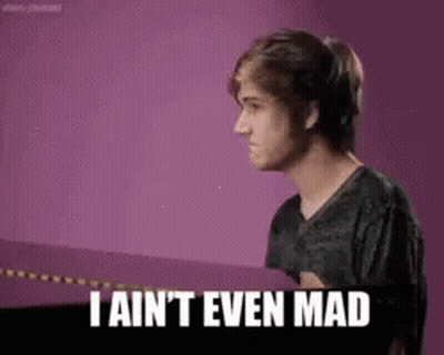 A Young Man Is Standing In Front Of A Purple Wall And Says `` I Ain 'T Even Mad '' . GIF