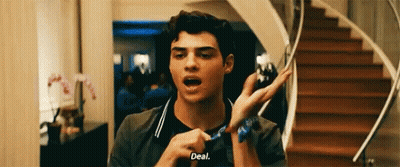 A Young Man Is Standing In Front Of A Set Of Stairs Holding A Scarf Around His Wrist . GIF