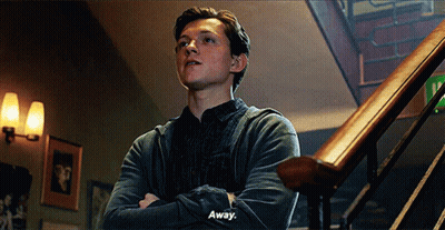 A Young Man Is Standing On A Set Of Stairs With His Arms Crossed And Saying `` Away '' . GIF