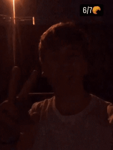 A Young Man Is Sticking His Tongue Out And Giving A Peace Sign . GIF