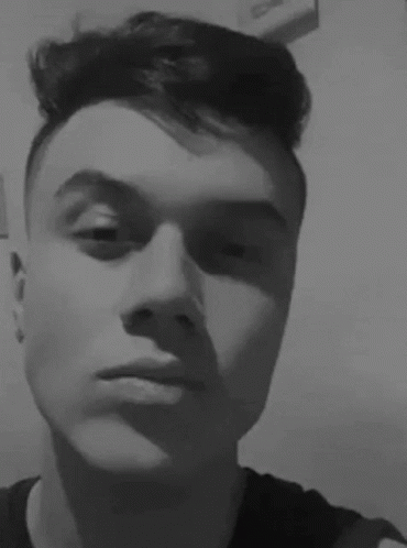 A Young Man Is Taking A Selfie In A Black And White Photo With His Eyes Closed . GIF
