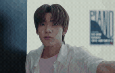 A Young Man Is Taking A Selfie In Front Of A Poster That Says Piano . GIF