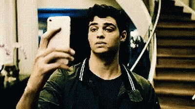 A Young Man Is Taking A Selfie With His Cell Phone In Front Of Stairs . GIF
