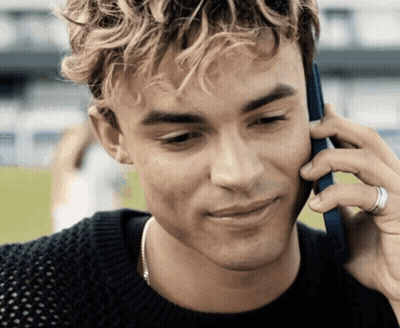 A Young Man Is Talking On A Cell Phone GIF