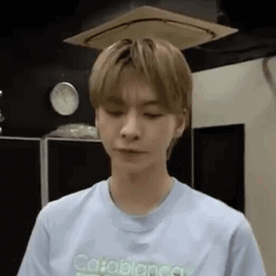 A Young Man Is Wearing A Light Blue T-Shirt And Looking At The Camera . GIF