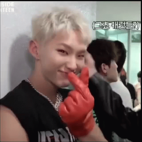A Young Man Is Wearing A Red Glove And Making A Heart Shape With His Fingers . GIF