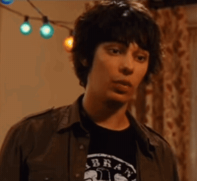 A Young Man Is Wearing A Shirt That Says Brat On It GIF