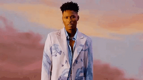 A Young Man Is Wearing A White Jacket And A Blue Shirt . GIF