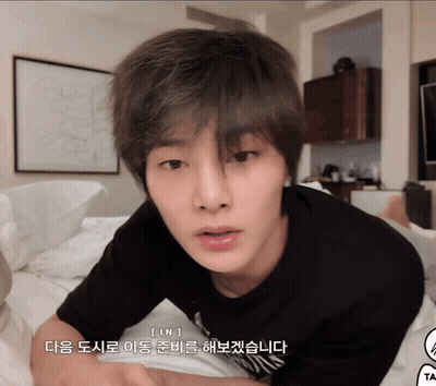 A Young Man Laying On A Bed With Korean Writing On The Bottom Of His Face GIF