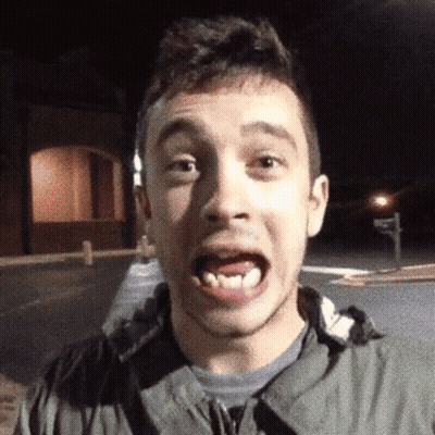A Young Man Making A Funny Face While Wearing A Grey Jacket GIF