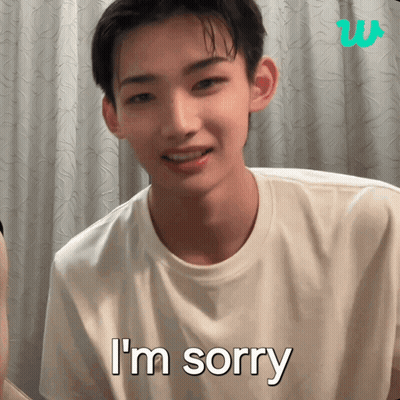 A Young Man Says I 'M Sorry In Front Of A White Curtain GIF
