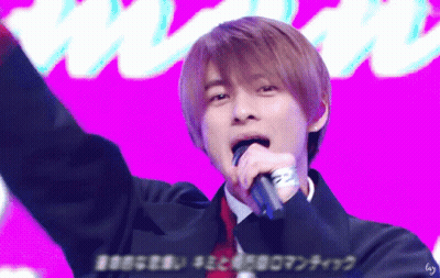 A Young Man Singing Into A Microphone With A Purple Background GIF