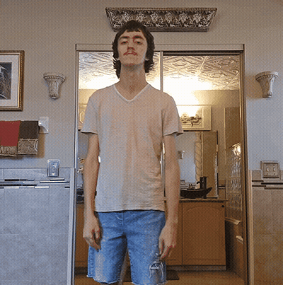 A Young Man Standing In Front Of A Sliding Glass Door In A Kitchen GIF