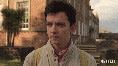 A Young Man Stands In Front Of A Building With A Netflix Logo On The Bottom Right GIF