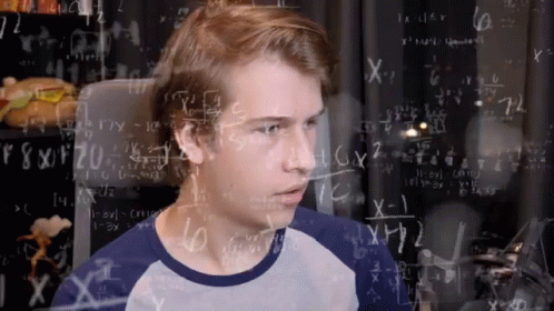 A Young Man Stands In Front Of A Chalkboard Filled With Math Equations GIF