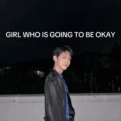 A Young Man Stands In Front Of A Poster That Says Girl Who Is Going To Be Okay GIF