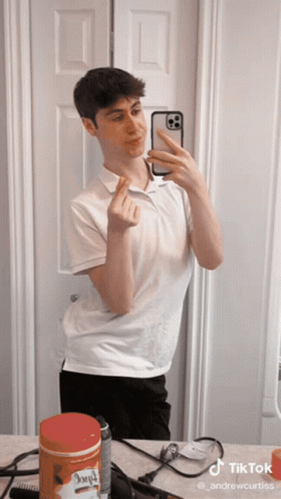 A Young Man Taking A Selfie In Front Of A Mirror With A Tiktok Watermark On The Bottom GIF