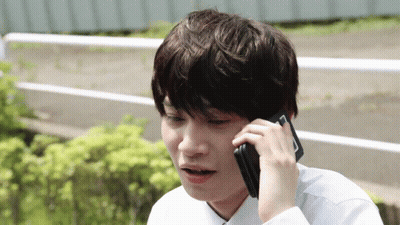 A Young Man Talking On A Cell Phone With A Surprised Look On His Face GIF