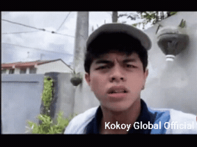 A Young Man Wearing A Baseball Cap Is Making A Funny Face With The Words Kokoy Global Official Written Below Him GIF