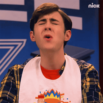A Young Man Wearing A Bib With The Word Nick On The Bottom GIF