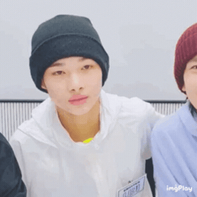 A Young Man Wearing A Black Beanie Is Smiling While Standing Next To Another Young Man . GIF