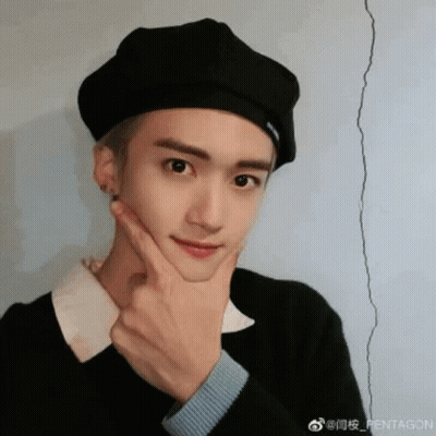 A Young Man Wearing A Black Beret Is Making A Funny Face With His Hand On His Chin . GIF