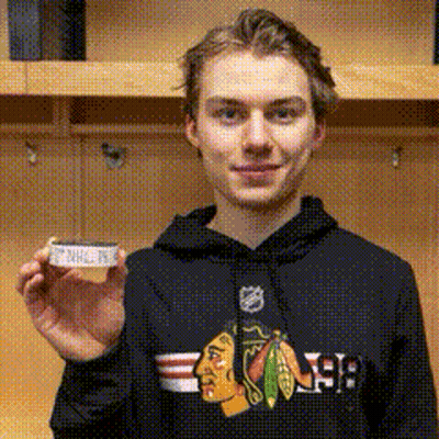 A Young Man Wearing A Black Chicago Blackhawks Hoodie Is Holding A Piece Of Paper GIF
