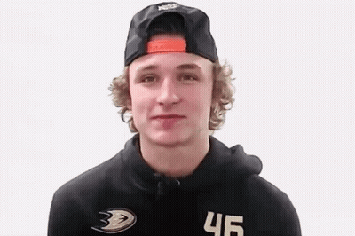 A Young Man Wearing A Black Hat And A Black Hoodie Is Looking At The Camera . GIF