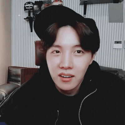A Young Man Wearing A Black Hat And A Black Jacket Looks At The Camera GIF