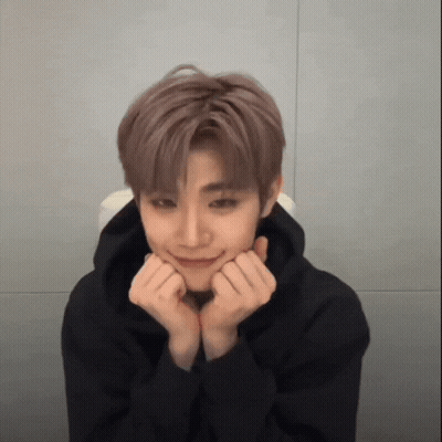 A Young Man Wearing A Black Hoodie Is Making A Face With His Hands On His Chin . GIF