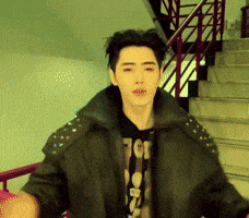 A Young Man Wearing A Black Jacket And A T-Shirt That Says Tcg GIF