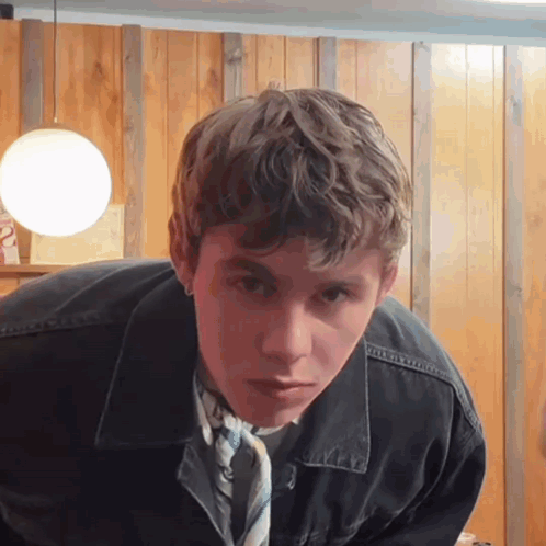 A Young Man Wearing A Black Jacket And A Tie GIF