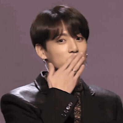 A Young Man Wearing A Black Jacket And Earrings Is Clapping His Hands GIF