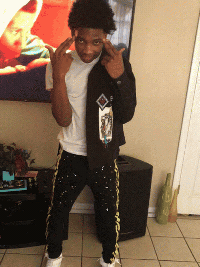 A Young Man Wearing A Black Jacket With A Picture Of A Baby On It GIF