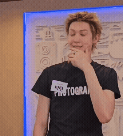 A Young Man Wearing A Black Photographer T-Shirt GIF