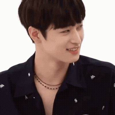 A Young Man Wearing A Black Shirt And A Necklace With The Letter W On It GIF