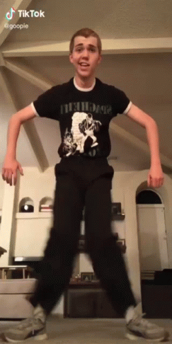 A Young Man Wearing A Black Shirt That Says Nirvana GIF