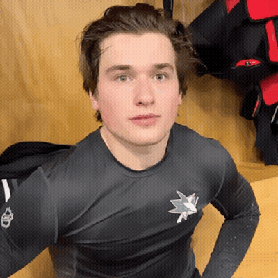 A Young Man Wearing A Black Shirt With A Shark Logo On It GIF