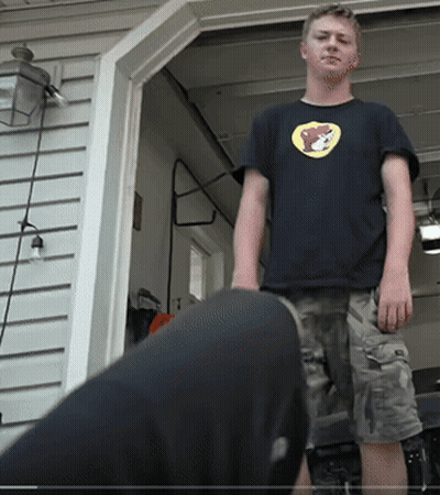A Young Man Wearing A Black Shirt With A Yellow Bear On It GIF